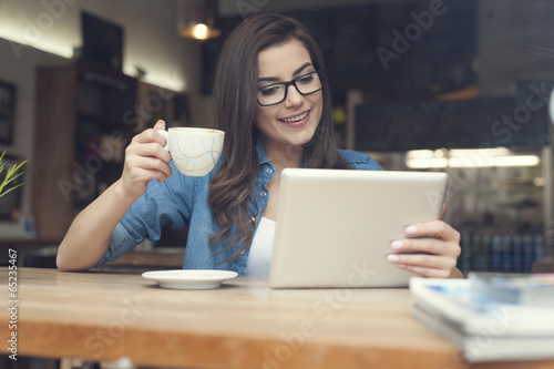 Woman using digital tablet at cafe