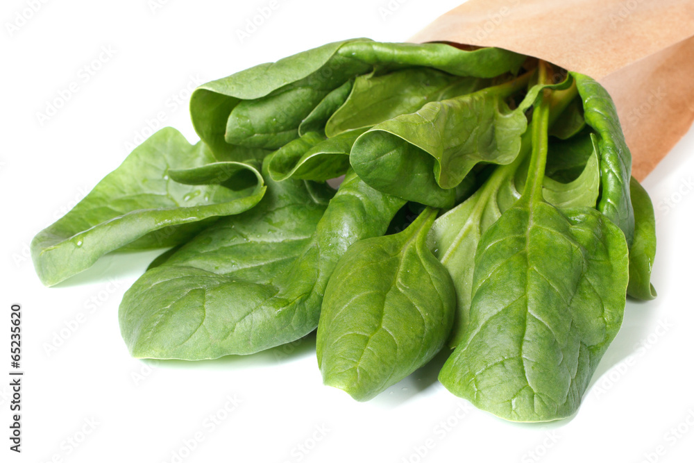 Spinach leaves in paper packing isolated on a white Spinach leaves in paper packing isolated on a white