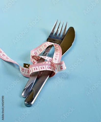 Cutlery with a centimetric tape around it photo