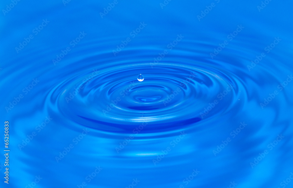 a drop of water falling in blue water a drop of water falling in blue water