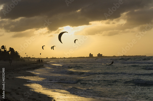 Professional kiter makes the difficult trick on a sunset