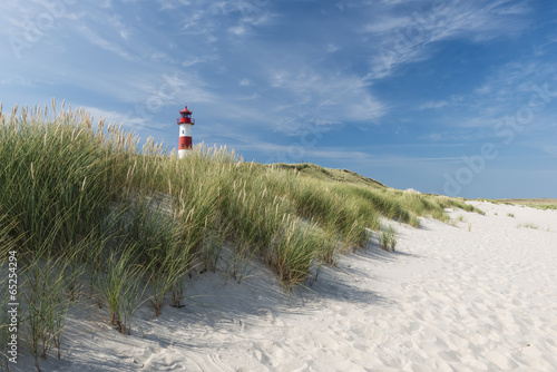 Fototapeta Naklejka Na Ścianę i Meble -  Red - white lightouse on wide dune on amazing German island Sylt.