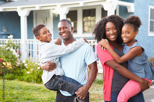 Portrait Of Family Outside Suburban Home