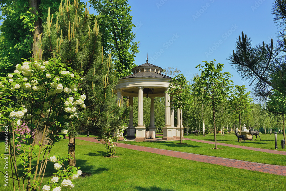 Fragment of a beautiful place to relax    in the Mezhyrrya park near Kiev. Against the background of flowering trees, rhododendree bushes and a cozy arbor.