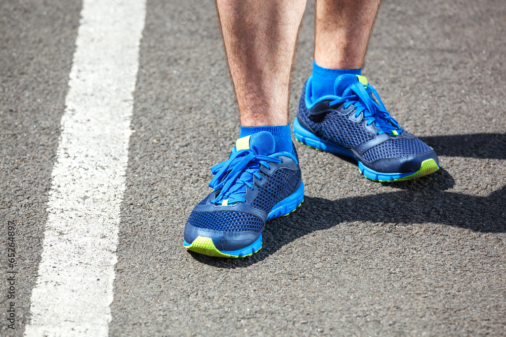 Closeup of a male runner standing - Fitness concept.