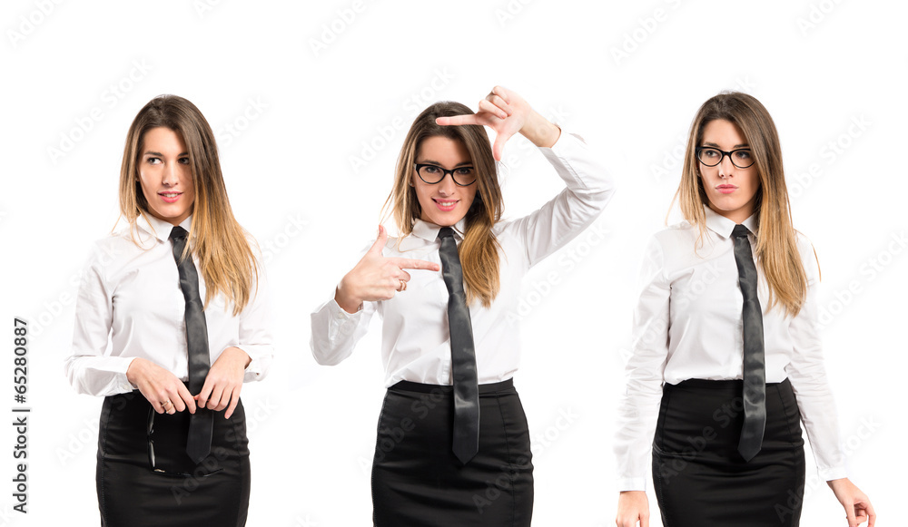 Pretty businesswoman focusing with her fingers on a white backgr Pretty businesswoman focusing with her fingers on a white backgr