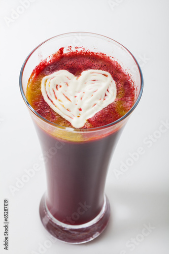 fresh squeezed juice in a tall glass with a white heart on top