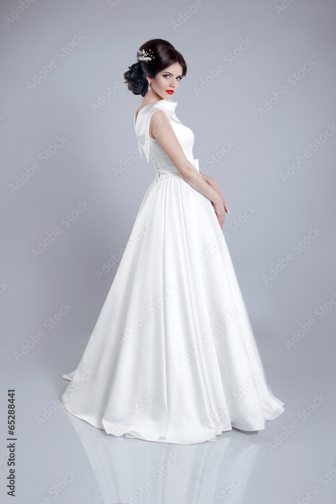 Fashionable bride model in wedding dress isolated on gray backgr Fashionable bride model in wedding dress isolated on gray backgr