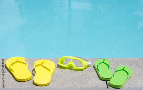 Color flip flops and water glasses by the pool