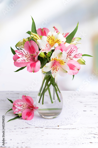 Fototapeta Naklejka Na Ścianę i Meble -  Alstroemeria flowers in vase on table on light background