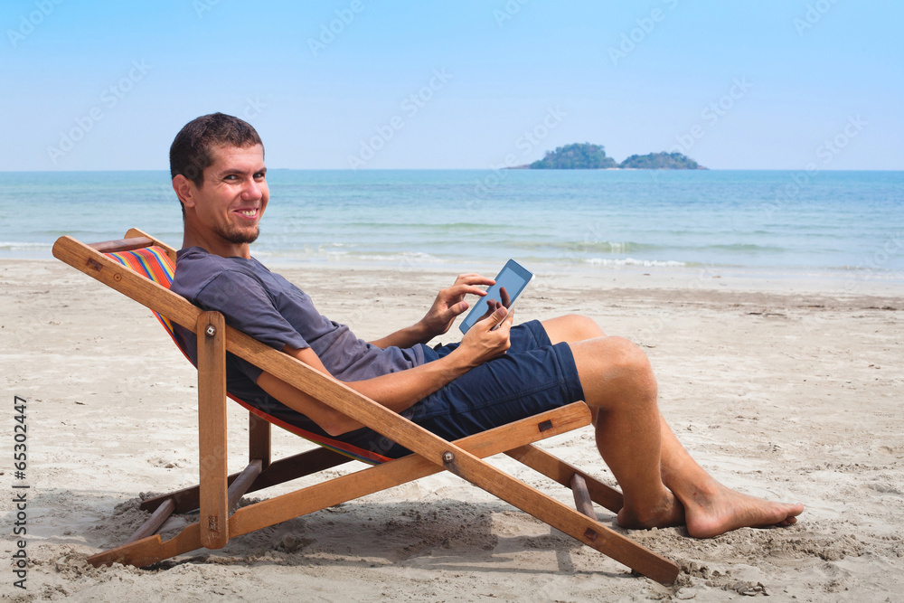 banking online, happy business man with tablet on the beach