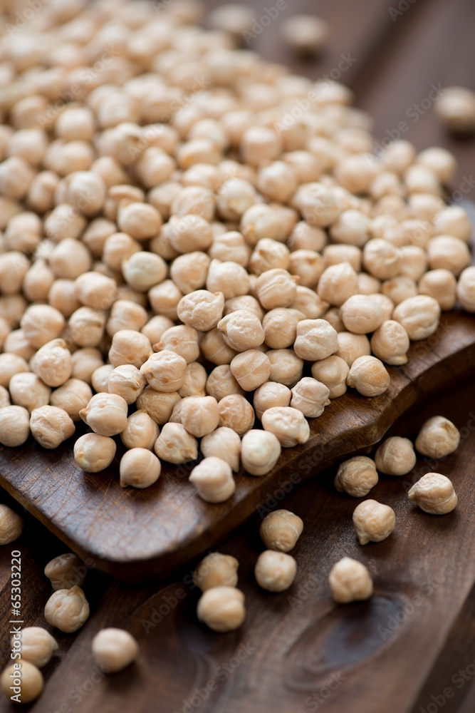 Raw chickpeas on a wooden cutting board, vertical shot Raw chickpeas on a wooden cutting board, vertical shot