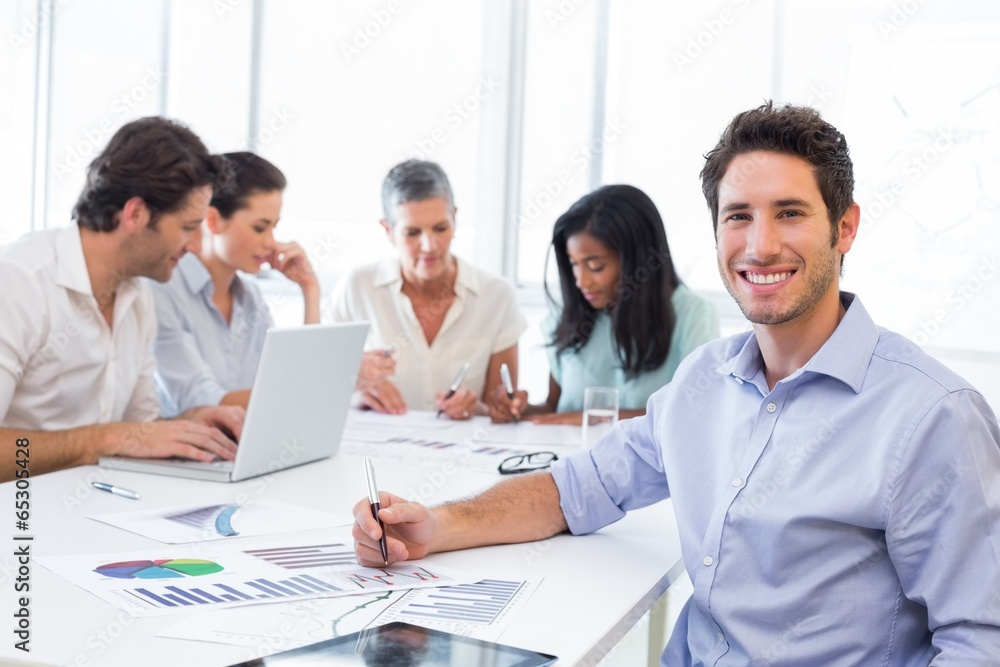 Handsome businessman smiling at the workplace Handsome businessman smiling at the workplace