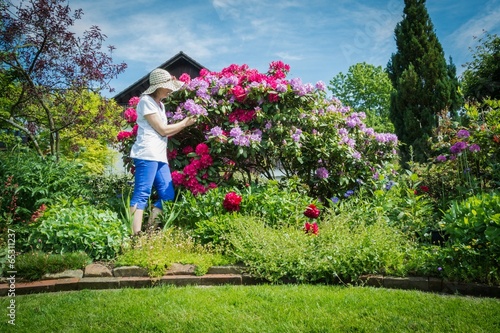 Frau im Garten mit Rhododendron