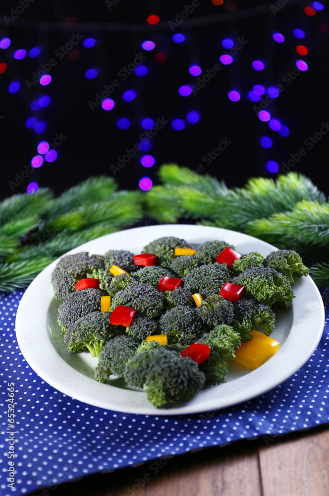 Christmas tree from broccoli on table on dark background Christmas tree from broccoli on table on dark background