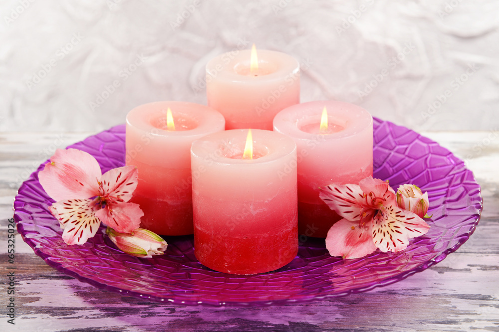Beautiful candles with flowers on table on grey background Beautiful candles with flowers on table on grey background
