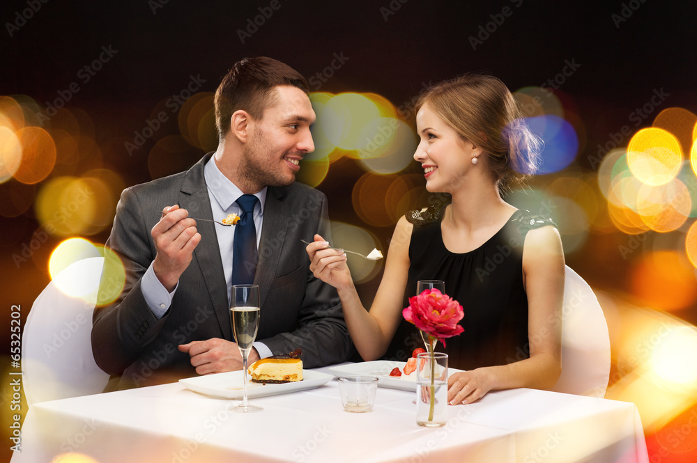 smiling couple eating dessert at restaurant smiling couple eating dessert at restaurant