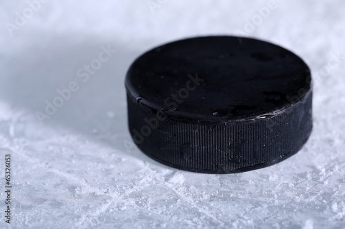 Photography Black hockey puck on ice rink background