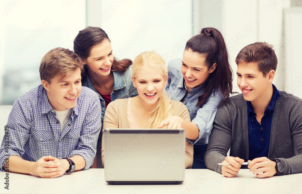 smiling students looking at laptop at school smiling students looking at laptop at school