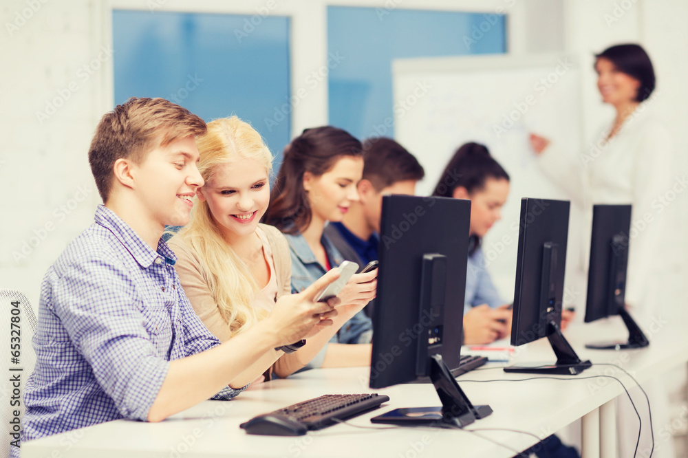 students with computer monitor and smartphones students with computer monitor and smartphones