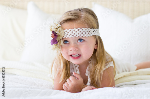 Little girl with headband on bed