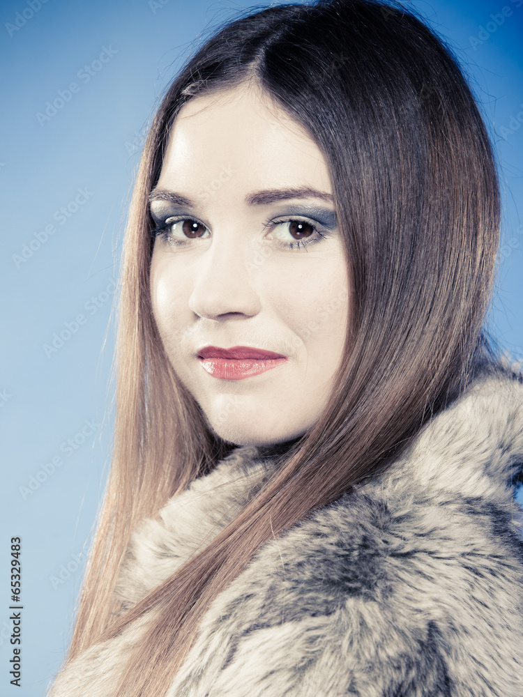 Portrait of girl with long hair. Woman in fur coat on blue. Portrait of girl with long hair. Woman in fur coat on blue.