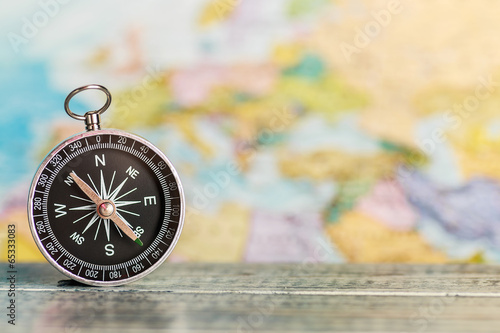 compass on the table against the background of a tourist map