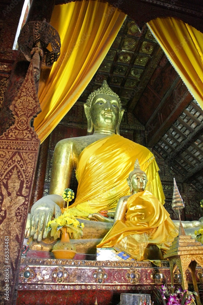 Obraz premium Buddha statue with yellow curtains