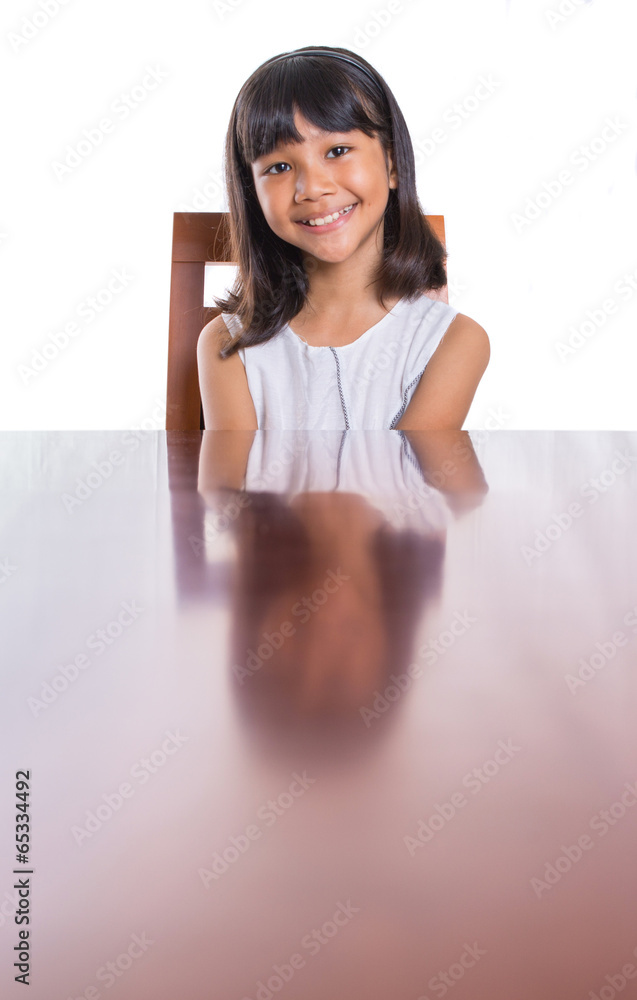 Young Asian girl sitting on a wooden chair Young Asian girl sitting on a wooden chair