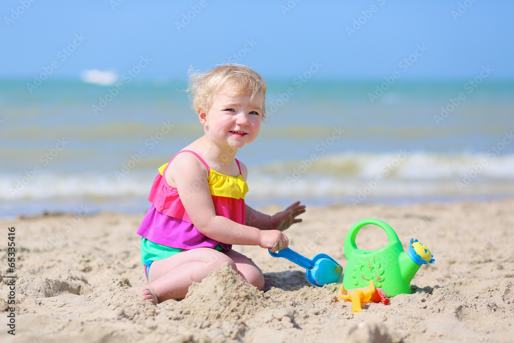 Cute little girl building sand castles on tropical beach Cute little girl building sand castles on tropical beach