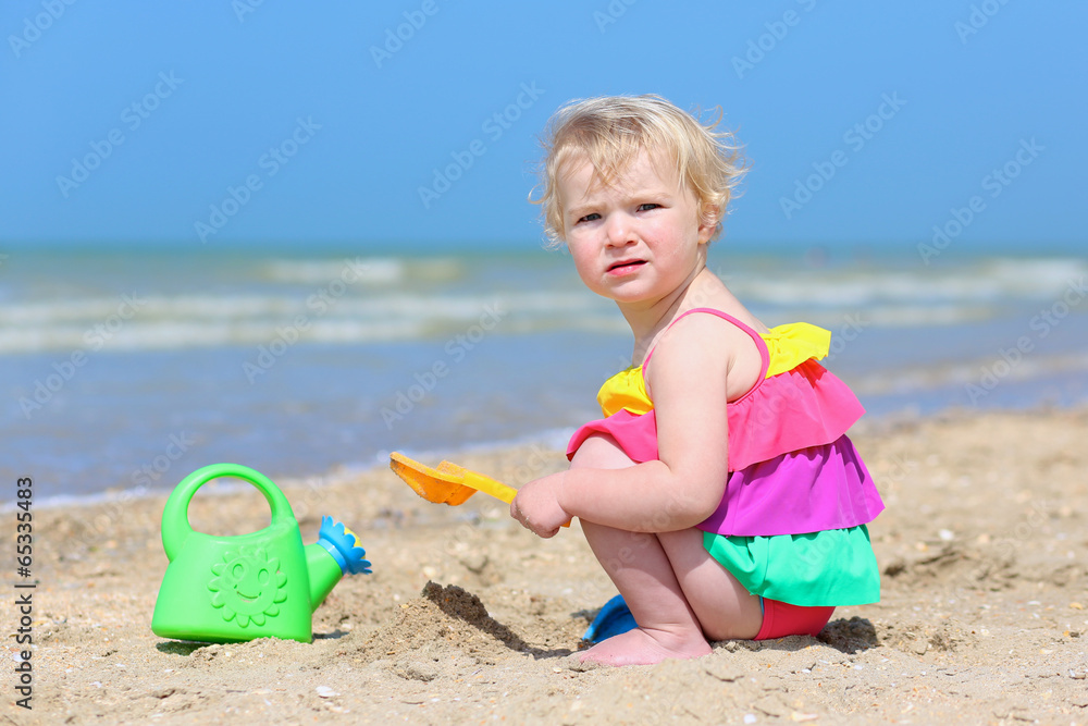 Cute little girl building sand castles on tropical beach Cute little girl building sand castles on tropical beach