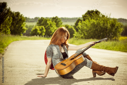 woman with guitar at freeway turn