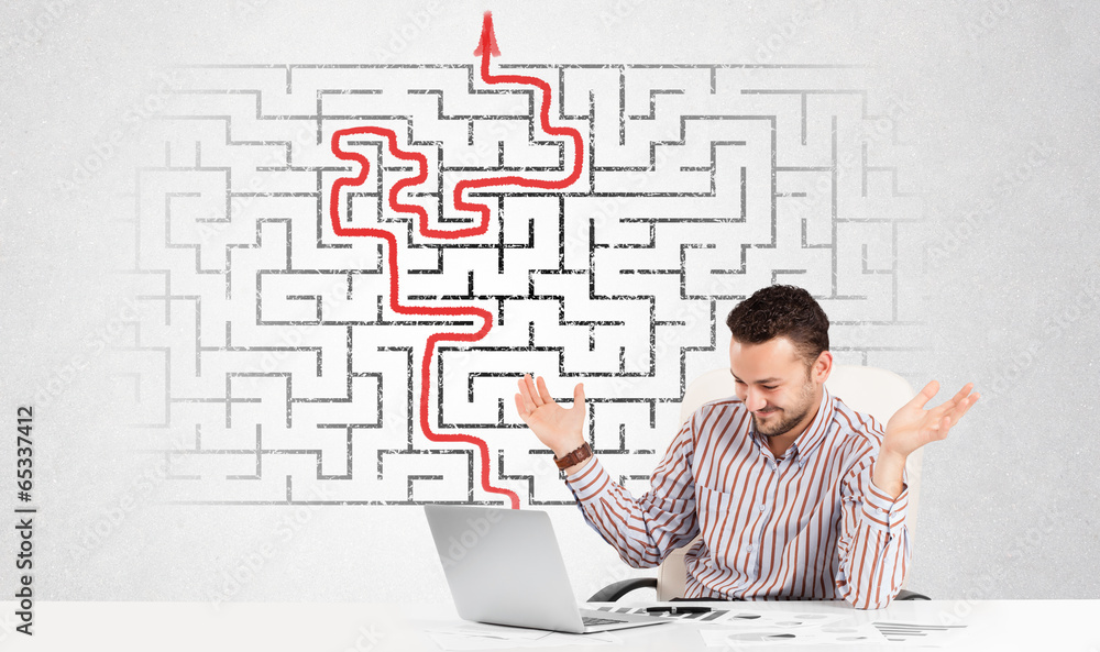 Business man at desk with labyrinth and arrow Business man at desk with labyrinth and arrow