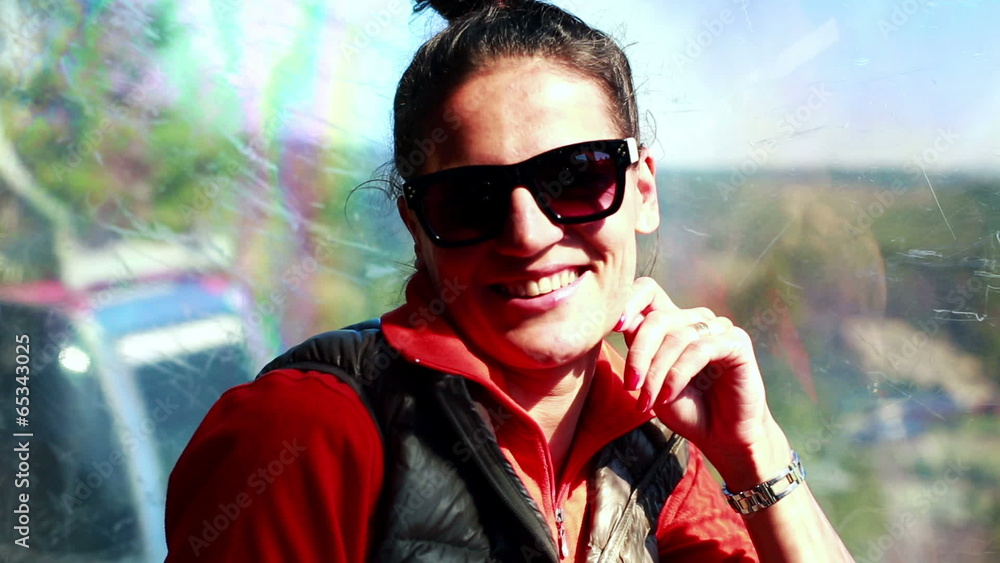 happy woman travelling in a cable car and smiling to the camera happy woman travelling in a cable car and smiling to the camera