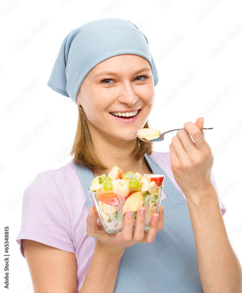 Young attractive woman is eating salad using fork Young attractive woman is eating salad using fork