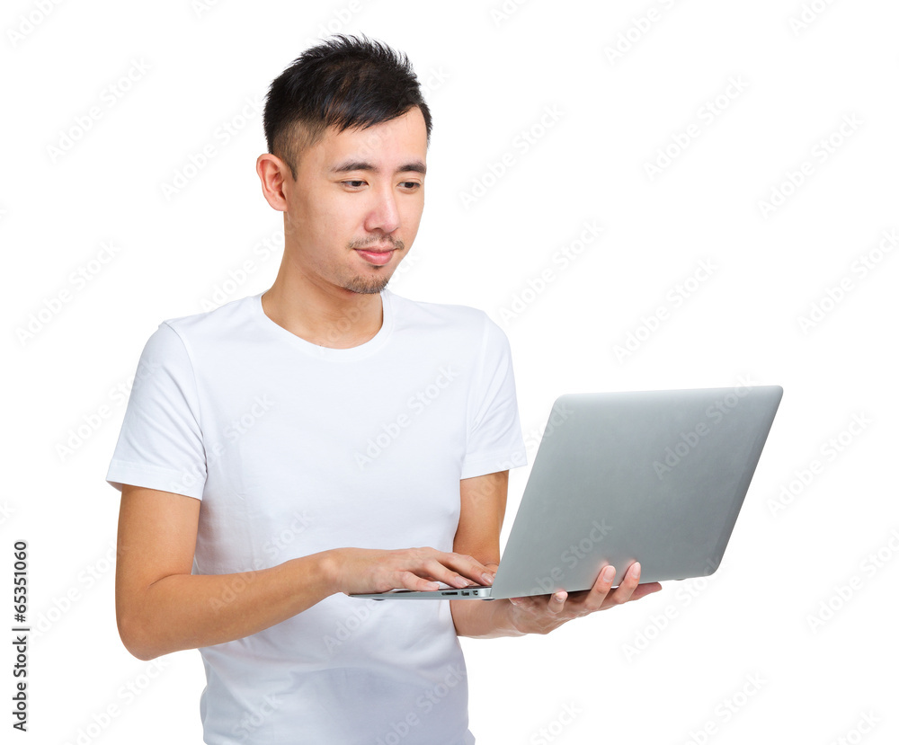 Asian man using laptop computer Asian man using laptop computer