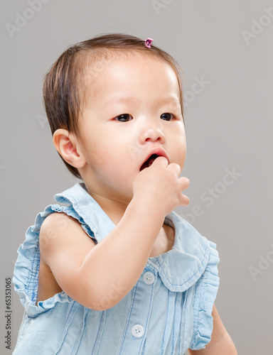 Baby girl put finger into mouth