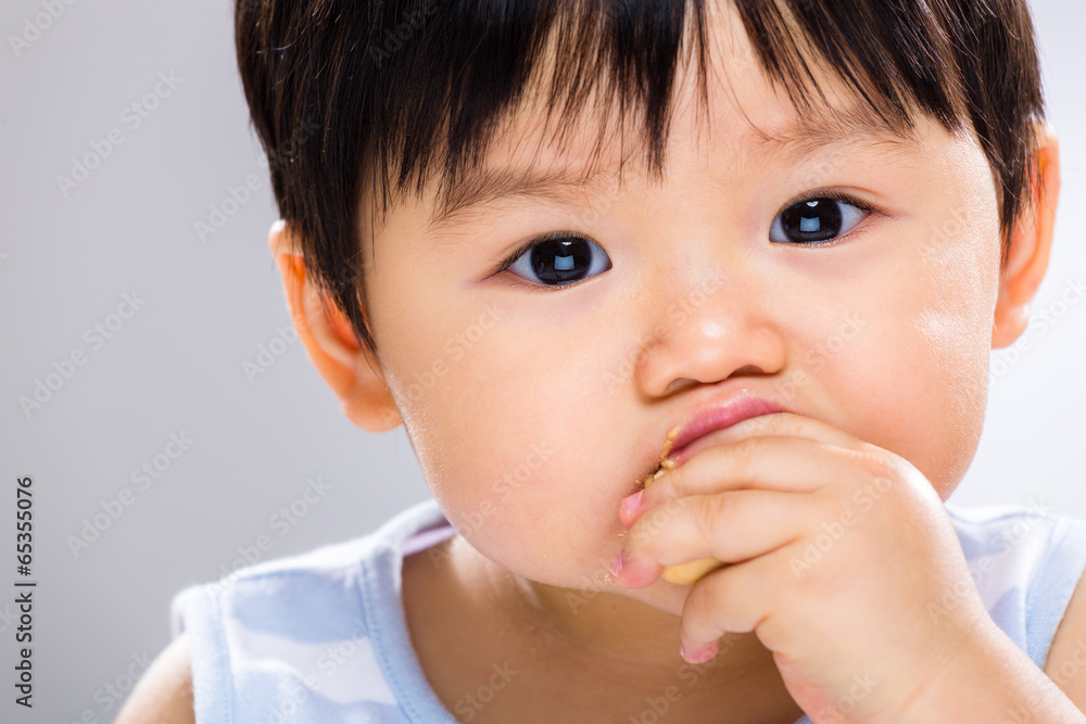 Little boy eating biscuit close up Little boy eating biscuit close up
