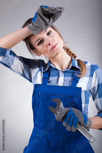 Tired woman holding wrench photo