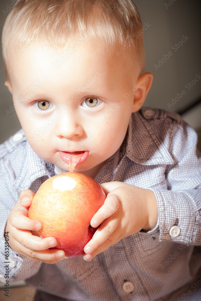 Cute baby boy eating red apple fruit Cute baby boy eating red apple fruit