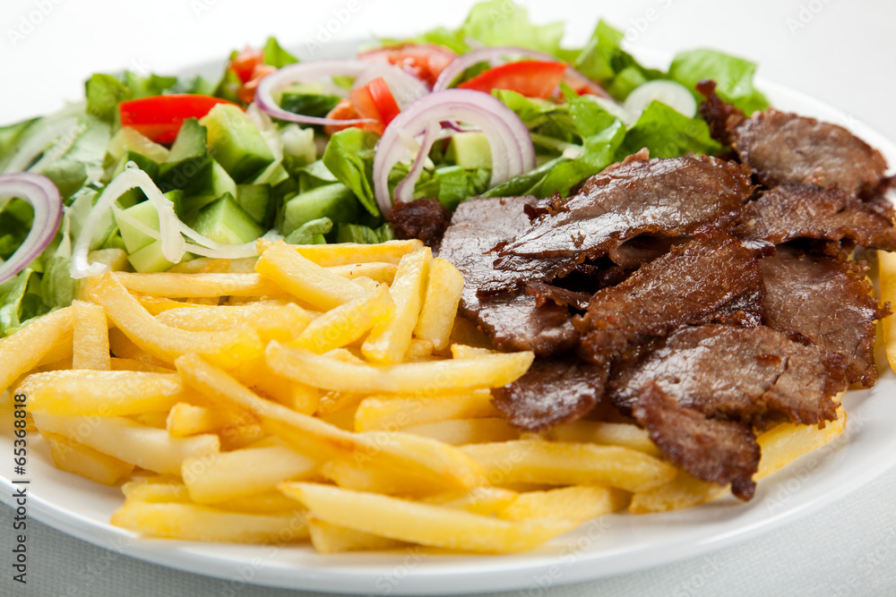 Grilled meat with French fries and vegetables Grilled meat with French fries and vegetables