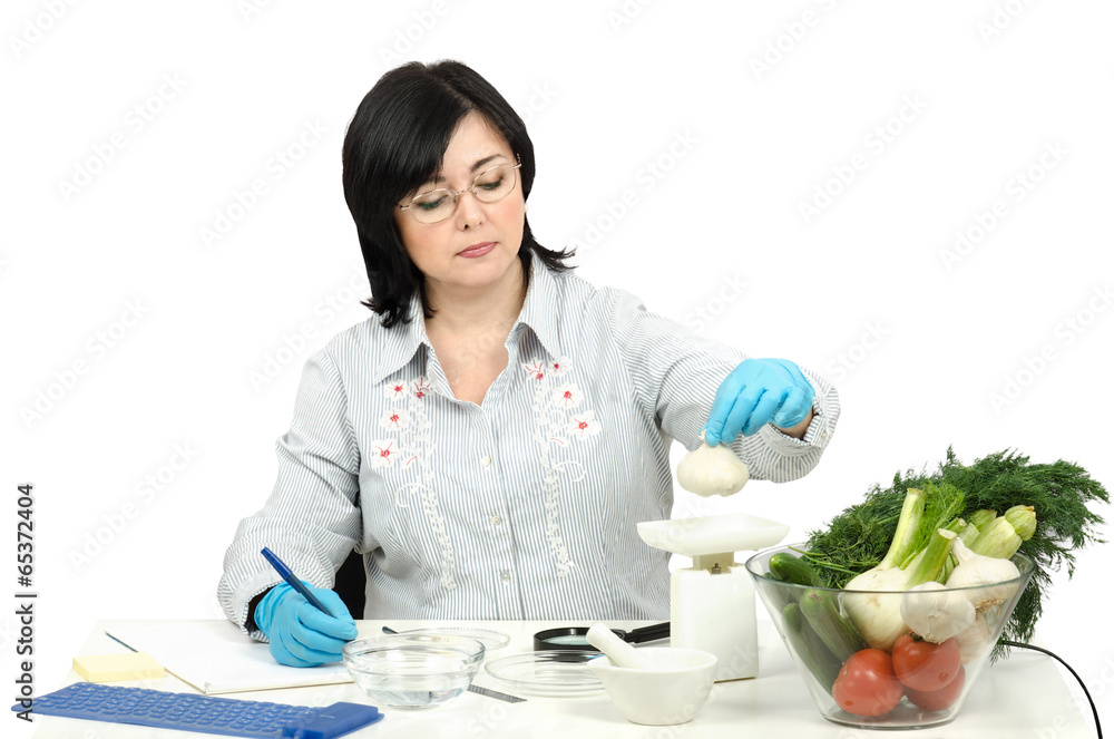 Phytocontrol technician weighing garlic bulb Phytocontrol technician weighing garlic bulb