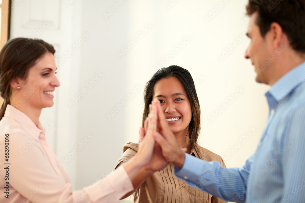 Charming coworkers team huddle their hands Charming coworkers team huddle their hands