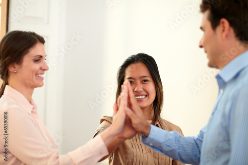 Charming coworkers team huddle their hands