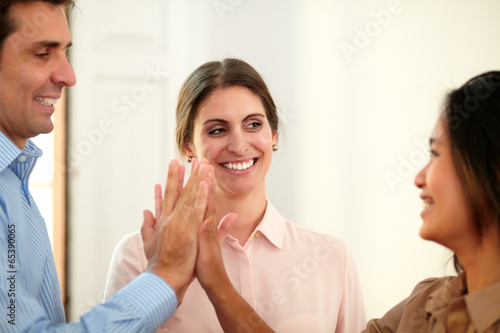 Businessman and businesswomen huddle their hands
