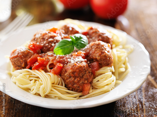 spaghetti and meatballs with basil garnish