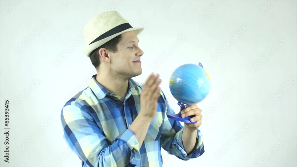 Attractive man holding a globe and pointing place Attractive man holding a globe and pointing place