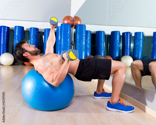 Dumbbell chest press on fit ball man workout photo