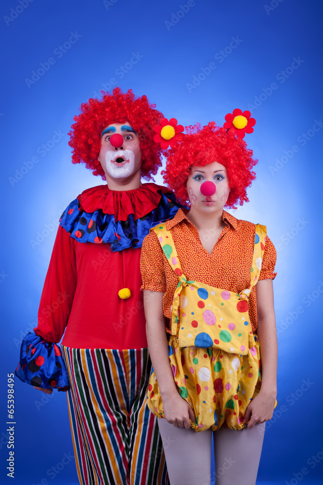 Clown couple in costumes on blue background Clown couple in costumes on blue background