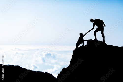 Man and woman help silhouette in mountains #65399858